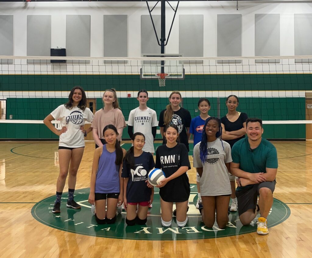 a group of volleyball players in front of a net